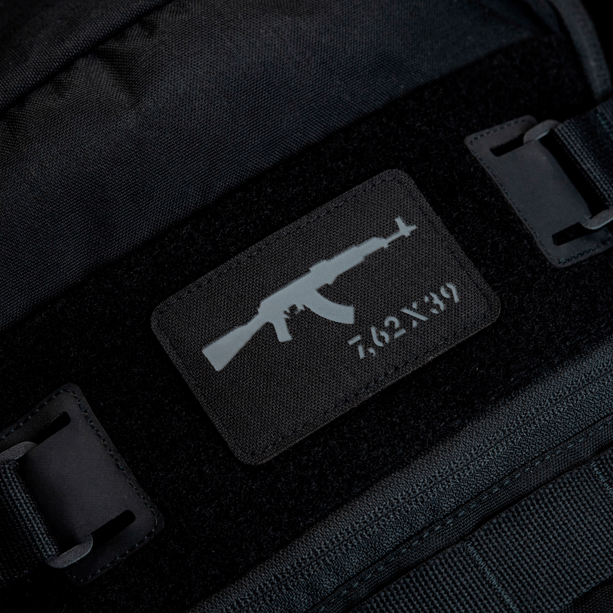 M-Tac AKM 7,62x39 Laser Cut Patch fastgjort på sort rygsæk, lavet af Cordura 500D, holdbar med Velcro hook, taktisk design til outdoor.