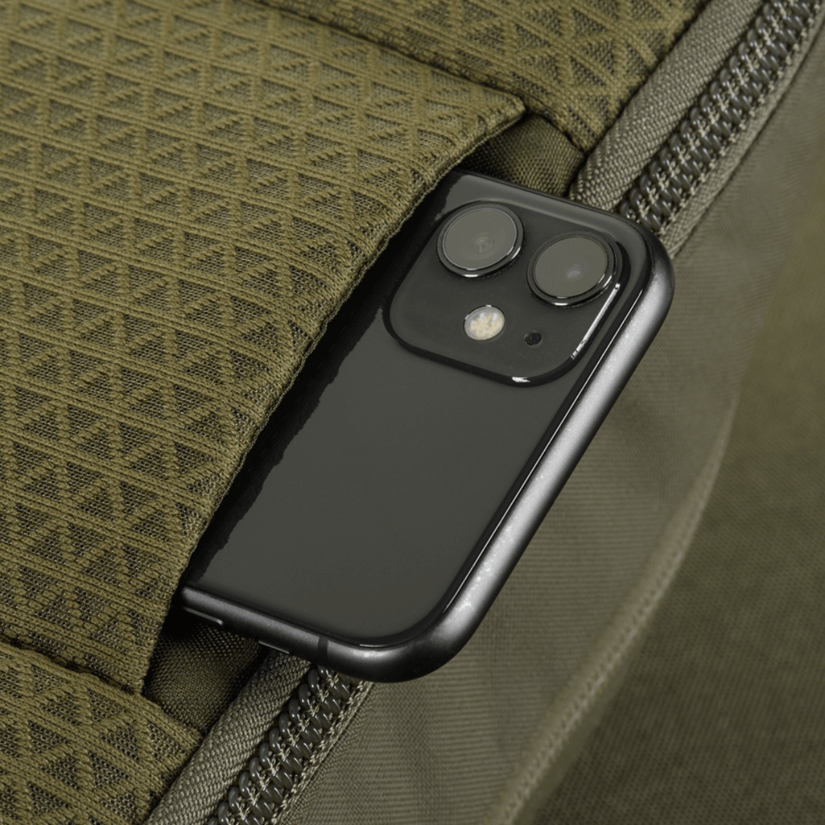 Nærbillede af M-Tac Sphaera Hardsling Bag Large Elite med Velcro med smartphone i en lomme, viser taske funktionalitet og detalje.