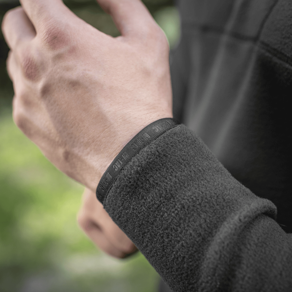 Mand iført M-Tac Delta Polartec Raglan Jakke viser fleece detalje og elastisk bånd, egnet til udendørs aktiviteter.