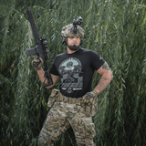 M-Tac T-Shirt Odin Mystery med print af Odin fra nordisk mytologi, båret af en person i militærudstyr foran en skovbaggrund.