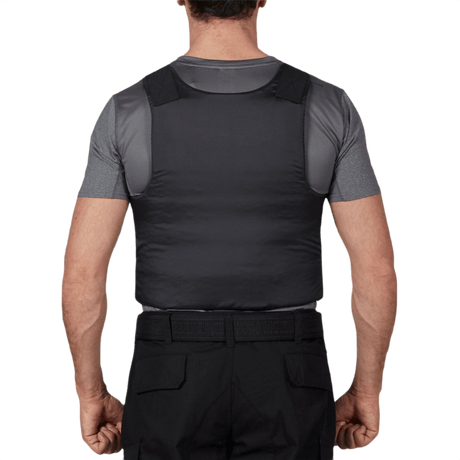 Mand i en "Anorak Concealable II Cover" vest for skjult bæring, visning bagfra, indendørs.