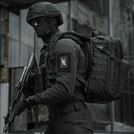 Taktisk operatør iført "M-Tac Patch Bad Boy (Broderi)" med kaninkranium på ace of spades kort, holdende våben, i urban indstilling.