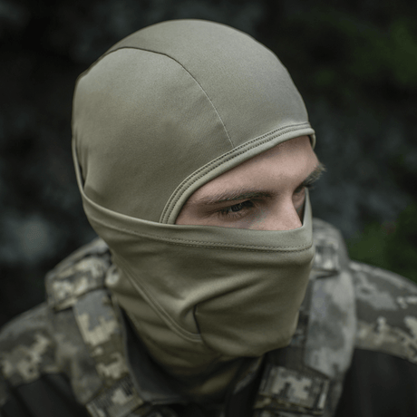 M-Tac Sweater-Ninja-Balaclava Premium til ansigtsbeskyttelse med Polartec® Power Dry-materiale i camouflage-miljø.