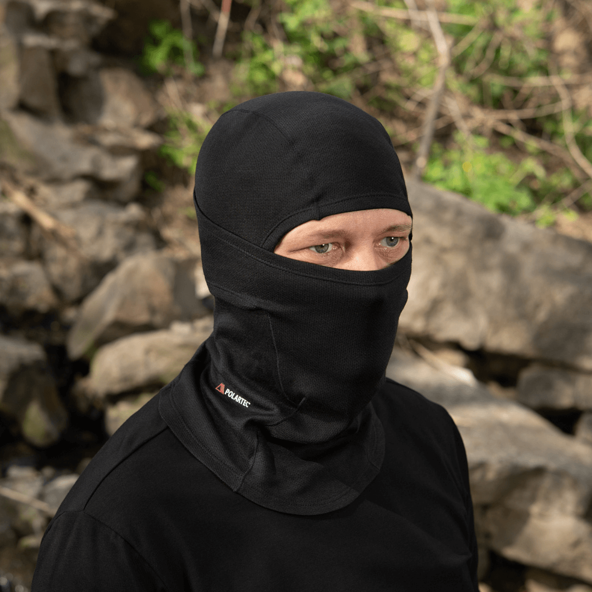 Mand bærer M-Tac Sweater-Ninja-Balaclava Premium i sort udendørs, optimal til komfort og fugthåndtering, med flade sømme og elastisk stof.