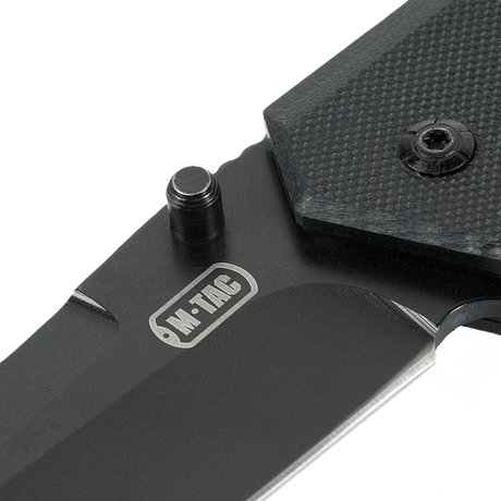 M-Tac Outdoor & Militær foldekniv - Type 5 med G10-komposit håndtag i nærbillede, viser rustfrit stål klinge og logo