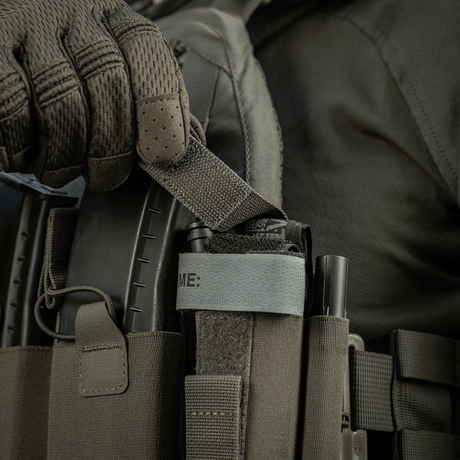 M‑Tac Tourniquet Pouch Elastic Gen.5 monteret på taktisk udstyr, viser hurtig adgang til tourniquet med elastisk velcrobånd.