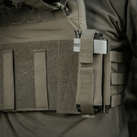 M‑Tac Tourniquet Pouch Elastic Gen.5 monteret på taktisk udstyr, viser sikker fastgørelse med elastisk bånd og velcro.