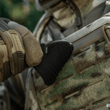 Taktisk handske justerer sort velcro-patch på camouflagedragt udendørs