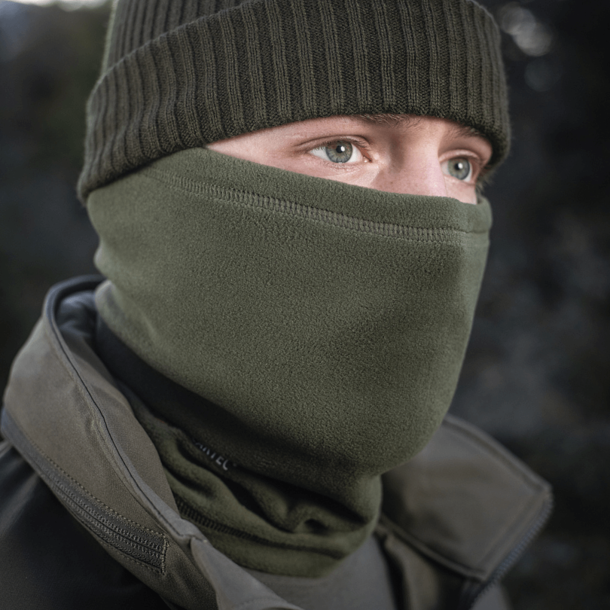 Person iført M-Tac Tube Scarf Polartec som ansigtsmaske til beskyttelse mod kulde udendørs om vinteren.