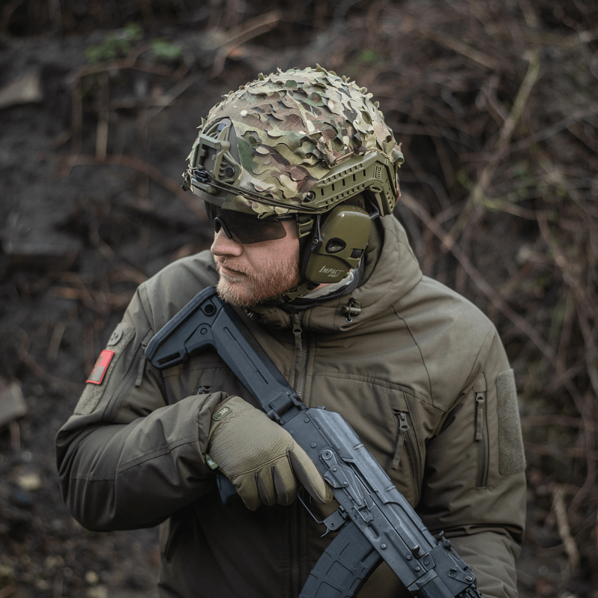 M‑Tac Vilha Hjelmcover FAST på en hjelm med camouflage i ujævnt terræn, fremstillet af Cordura 500D for holdbarhed.