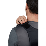 Person iført Anorak Niobium® Concealable III Stik & Skudsikker Vest med hånden på skulderen, viser vestens diskrete design.