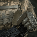 Soldat iført taktisk udstyr og handsker installerer M-Tac Patch M67 Granat 3D PVC med velcro-bagside på uniform i camouflage.